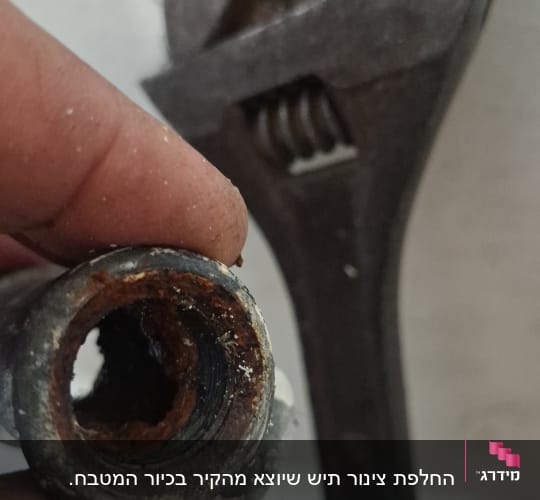 צינור חלוד ומפתח ברגים על קיר